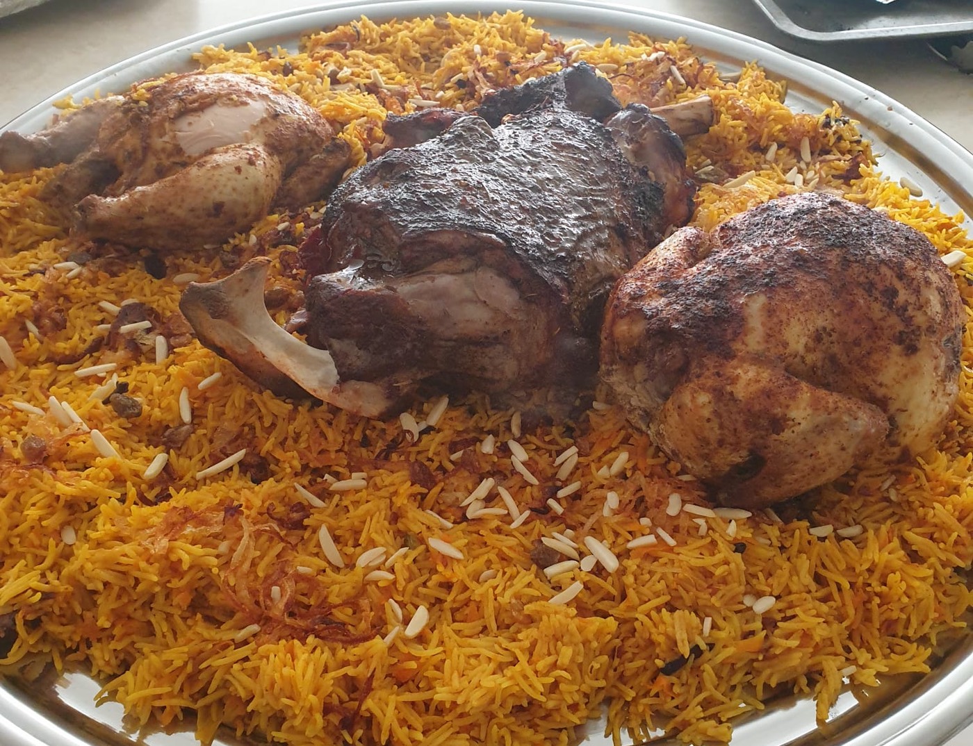 Chicken mandi — roast chicken and lamb on spiced rice with almonds